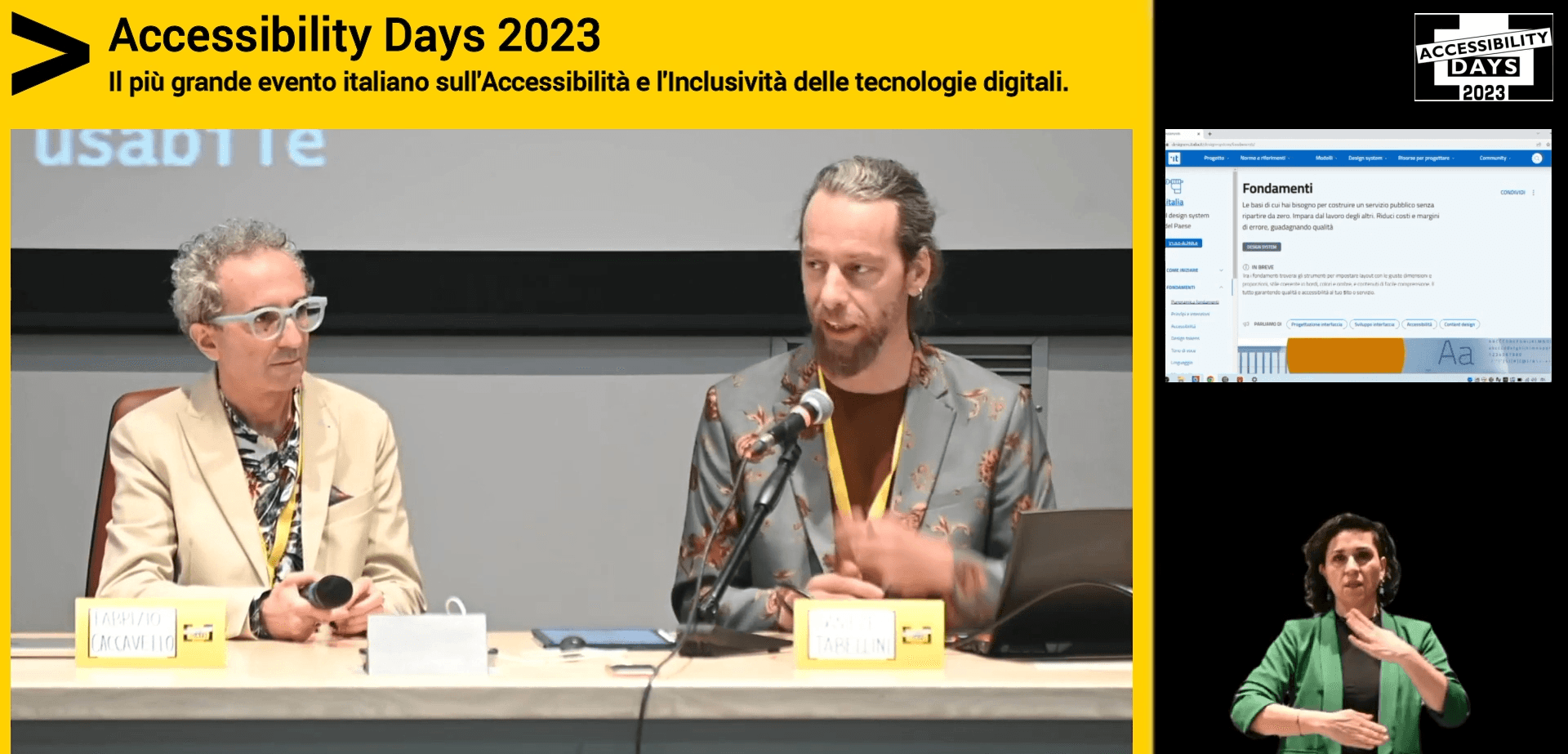 Accessibility Days - Il più grande evento italiano sull'accessibilità e l'inclusività delle tecnologie digitali. L'immagine mostra Daniele Tabellini e Fabrizio Caccavello ritratti mentre parlano durante l'evento. A destra, sono presenti due riquadri: in uno è mostrato lo schermo dei relatori, nell'altro una persona che traduce il discorso in lingua dei segni.